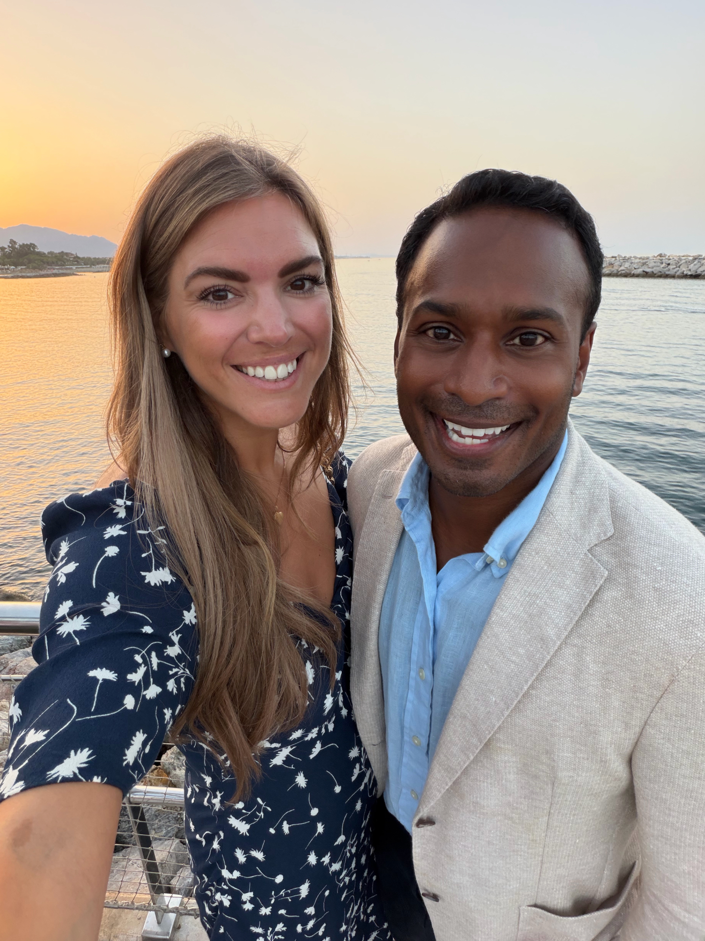 Katarina and Daniel smiling together by the sea at sunset